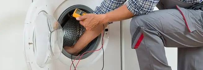 Dryer repair technician inspecting and repairing a clothes dryer in Savannah, GA