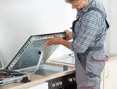 Appliance repair technician installing a built-in cooktop in Savannah, GA