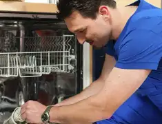 Dishwasher repair technician inspecting and servicing an open dishwasher in Savannah, GA