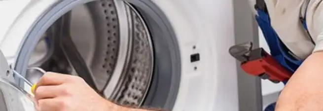 Appliance technician repairing a clothes dryer drum and internal parts in Savannah, GA