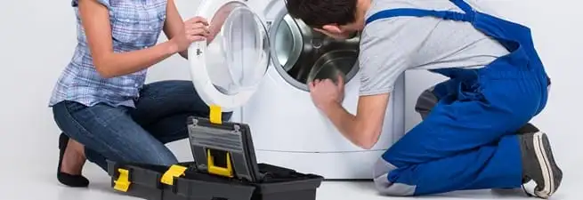 Washer repair technician inspecting a front-load washing machine with tools in Savannah, GA
