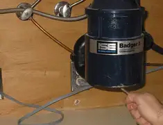 Garbage disposal repair technician tightening the mounting ring under a sink in Savannah, GA