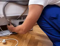 Appliance repair technician fixing refrigerator water line and connections in Savannah, GA