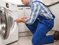 Washing machine repair technician servicing a front-load washer in Savannah, GA