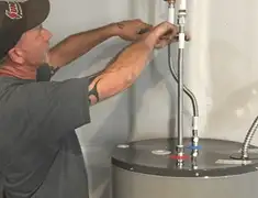 Water heater repair technician tightening supply line connections in Savannah, GA
