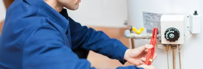 Water heater repair technician adjusting the temperature control and gas valve in Savannah, GA